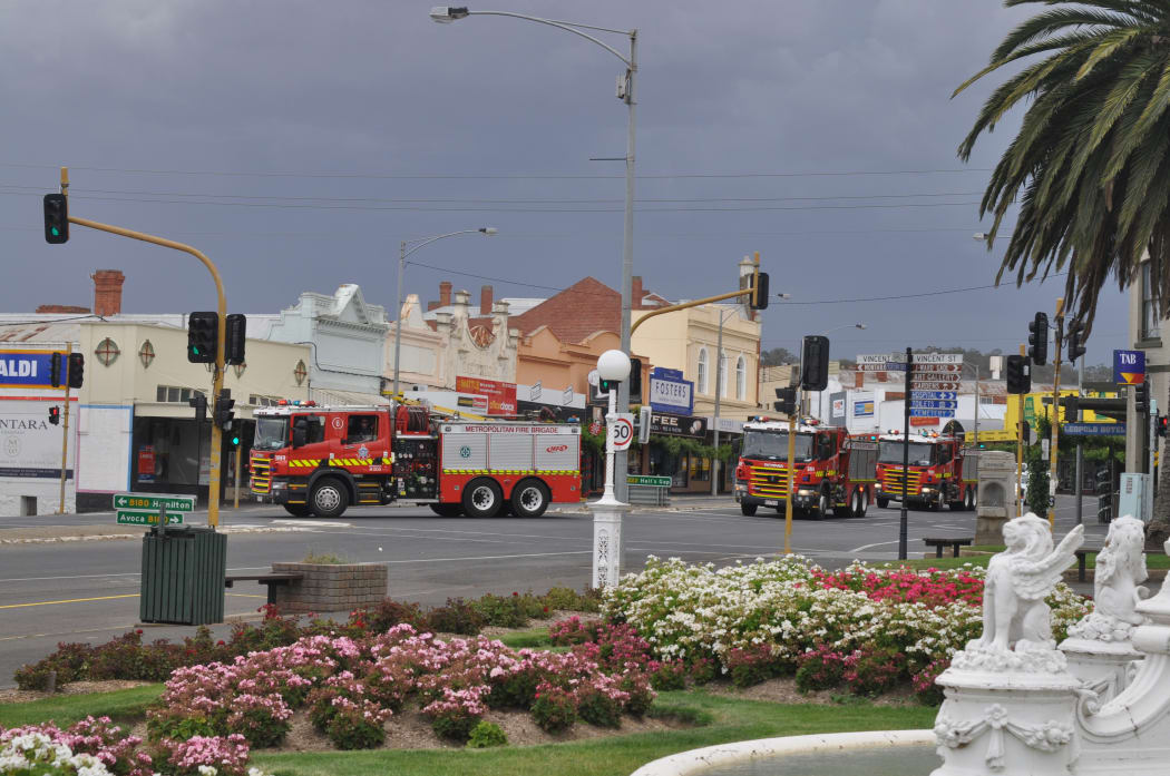 A convoy of CFA tankers roars through the centre of Ararat, Victoria, as fires rage near the town.