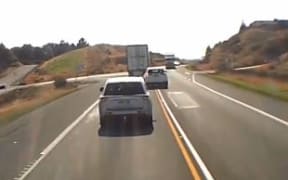 A white SUV overtaking Richard Collard's truck on a single yellow line on a sweeping right-hand bend before it attempts to pass another truck.