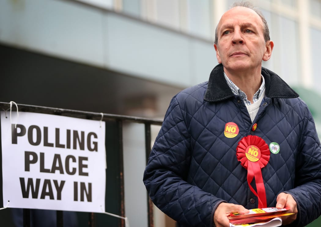 A pro-union campaigner waits to distribute leaflets to voters at a polling station in west Glasgow