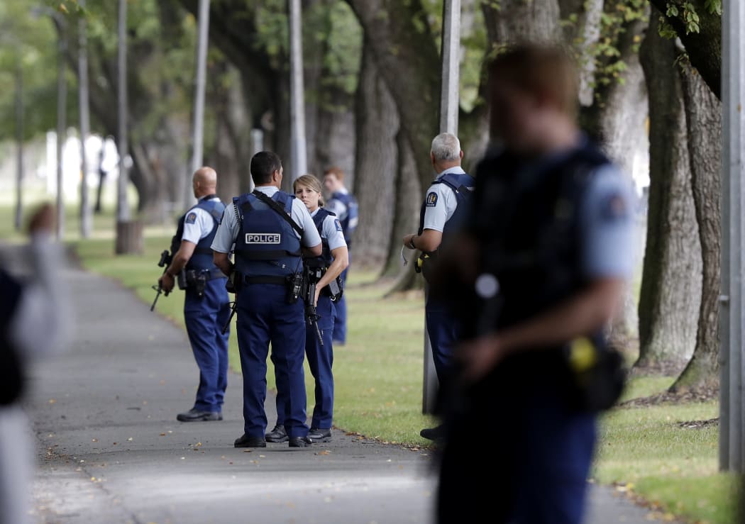 Police keep watch at a park across the road from a a mosque in central Christchurch, New Zealand