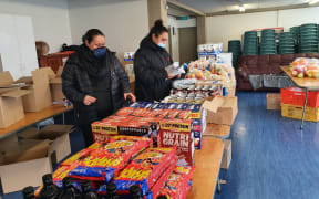 Emeline Afeaki-Mafile'o (left) and Melenaite Lausi’i prepare food parcels for their community organisation Affirming Works in Ōtāhuhu.