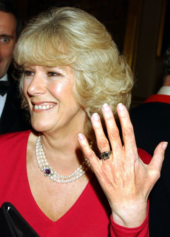 Camilla Parker Bowles shows off her engagement ring as she and Prince Charles arrive for a party at Windsor Castle after announcing their engagement earlier 10 February, 2005.  Britain's Prince Charles and his longtime companion Camilla Parker Bowles are to marry, his office announced Thursday, putting the official seal on a relationship that first blossomed 35 years ago.     AFP PHOTO/JOHN STILLWELL/WPA POOL (Photo by JOHN STILLWELL / POOL / AFP)