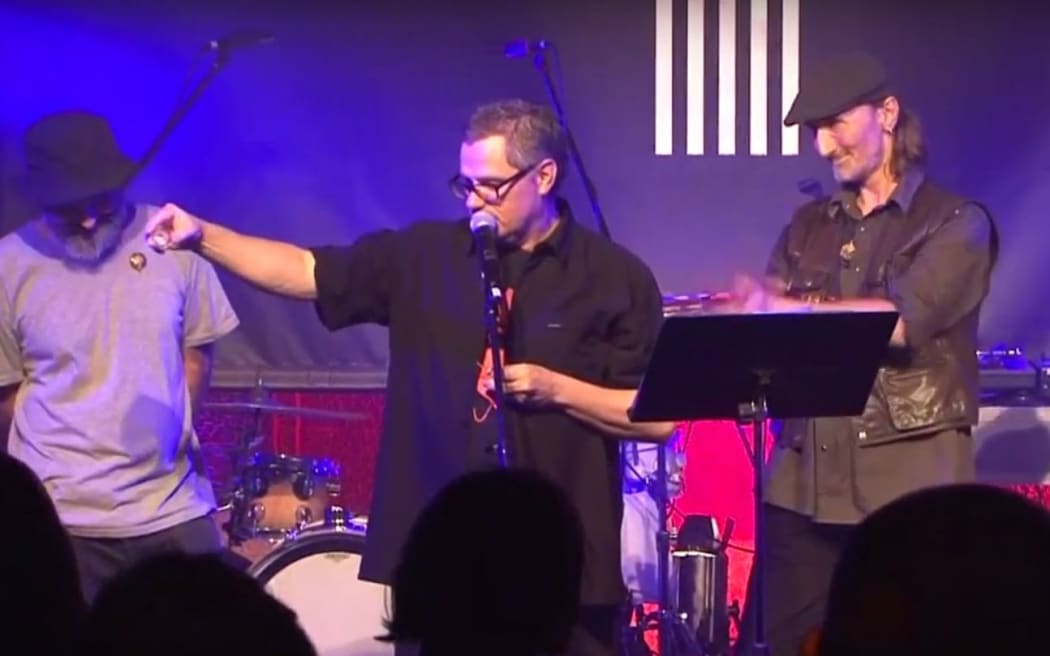 Headless Chickens frontman Chris Matthews sprinkles the ashes of Grant Fell out on the stage at the 2018 Taite Music Awards.