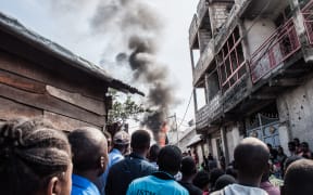 Residents react after a small aircraft carrying 18 people crashed in Goma on the East of the Democratic Republic of Congo on 24 November, 2019.