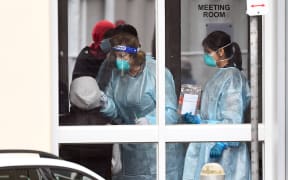 Medical staff perform a COVID-19 coronavirus test on a resident of one of nine public housing estates locked down due a spike in infection numbers in Melbourne on July 6, 2020.