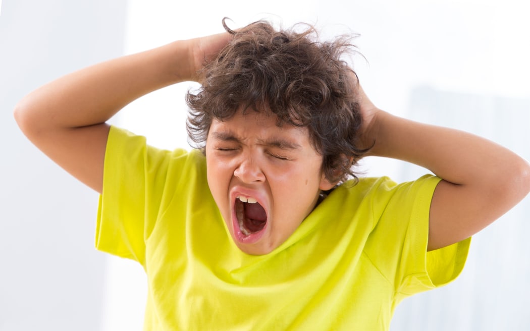 Boy scratching head.