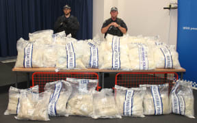 Sydney police officers stand near packages containing illicit drugs during a media conference last year.