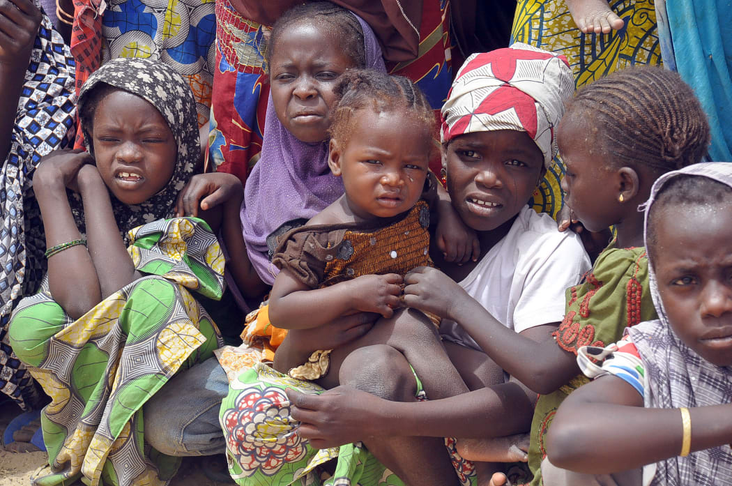 Families fleeing from Boko Haram attacks gather at a refugee camp.