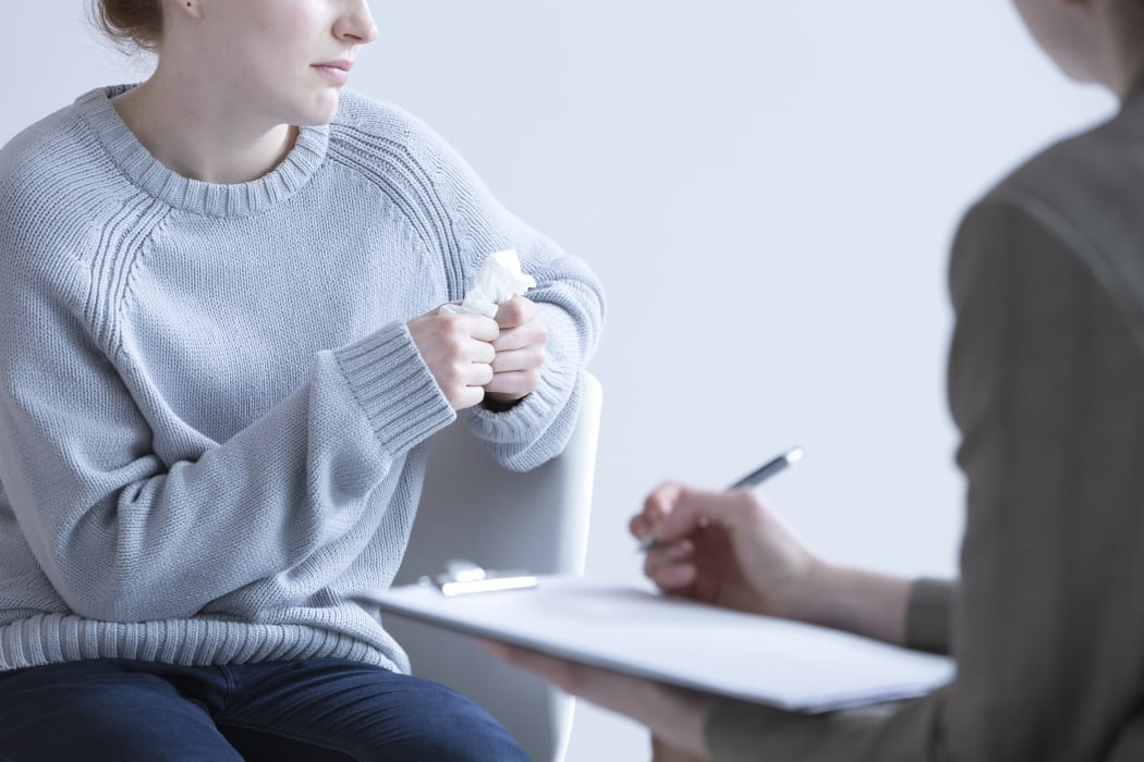 Crying woman suffering from depression and her psychologist