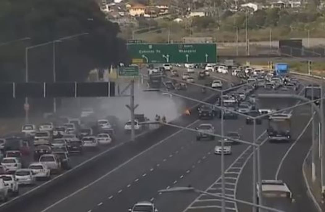 A vehicle on fire on State Highway 1 at Northcote in Auckland, blocking lanes in both directions.