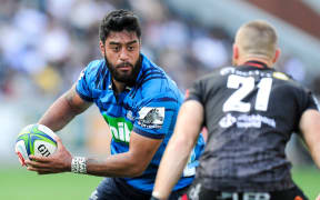 Akira Ioane of the Blues runs at the defence of Cameron Wright