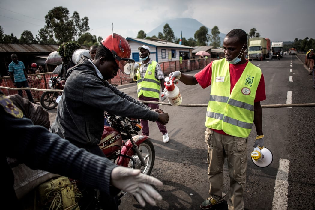 A motorcycle taxi driver gets his hands washed at an Ebola screening station on the road between Butembo and Goma, 16 July 2019.