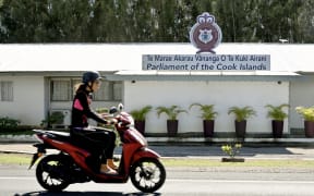 This photo taken on June 15, 2025 shows a person riding past the Parliament of the Cook Islands on the main island of Rarotonga. New Zealand's government halted aid to close partner the Cook Islands on June 19 because of a row over agreements the Pacific island nation struck with China. (Photo by William WEST / AFP)