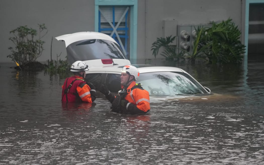 First responders in the water outside an apartment complex that was flooded from and overflowing creek due to Hurricane Milton on October 10, 2024 in Clearwater, Florida. - At least four people were confirmed killed as a result of two tornadoes triggered by Hurricane Milton on the east coast of the US state of Florida, local authorities said Thursday. (Photo by Bryan R. SMITH / AFP)