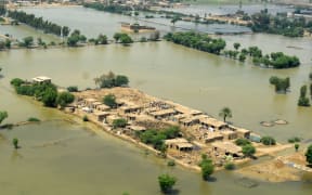This aerial photograph taken on 3 September, 2022 shows flood-affected people as they gather outside their damaged houses in Jaffarabad district, Balochistan province.