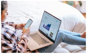 Woman checking investments via laptop.