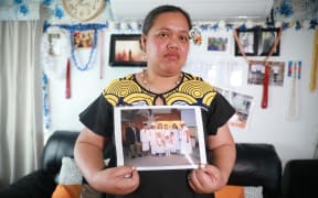 Nu'ulua Fa'aofo stands in her Kelston home holding a photo of her family after her husband, Uili Fa'aofo was killed in a car crash at Ramarama on Monday.