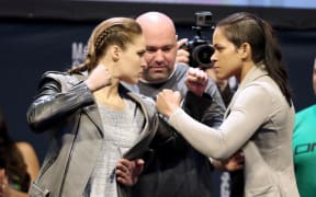 Ronda Rousey (L) and Amanda Nunes face off ahead of UFC title fight