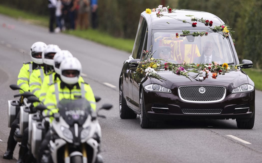 The hearse transporting the coffin of Queen Elizabeth II drives along Albert Road on the day of her state funeral and burial, in Windsor on September 20, 2022.