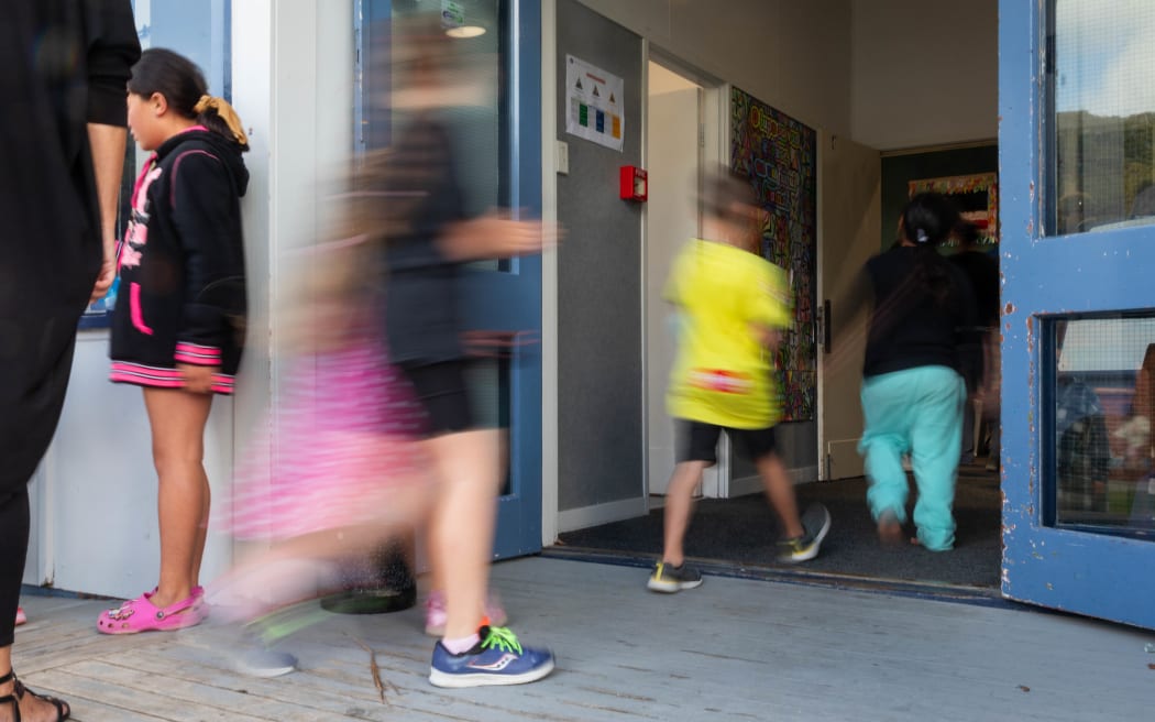 Children at Arakura School line up for free lunch