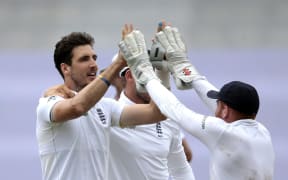 England's bowler Steven Finn (L) celebrates after dismissing South African captain Hashim Amla during the fourth day of the first cricket Test at Kingsmead on Dec 29, 2015 in Durban