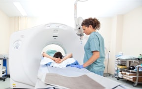 A woman goes through a CT scan.