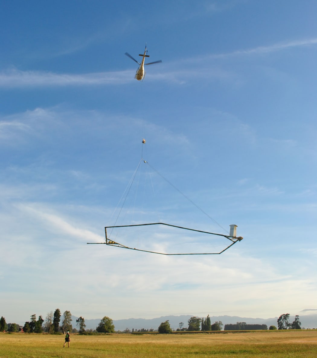 A helicopter with aerial electromagnetic (AEM) technology taking off.