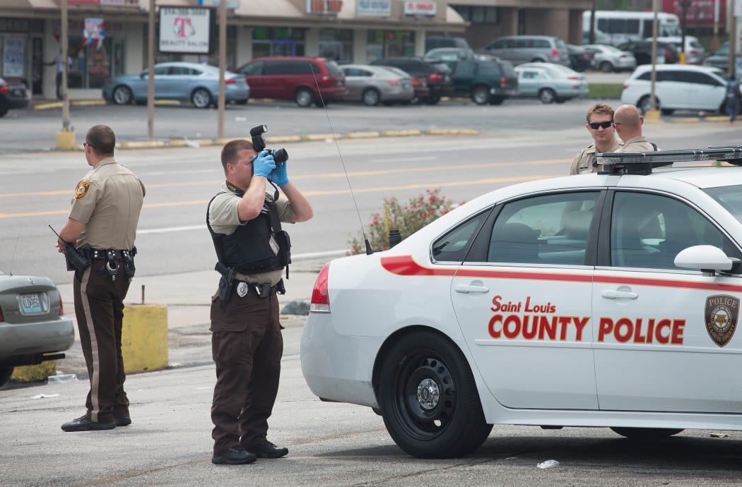 Police collect evidence the morning after the demonstration to mark the first anniversary of the shooting of Michael Brown in Ferguson, Missouri.