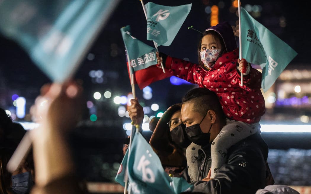 A child holds Taiwan People's Party (TPP) flags during an election campaign rally in Keelung on January 10, 2024. (Photo by I-Hwa CHENG / AFP)