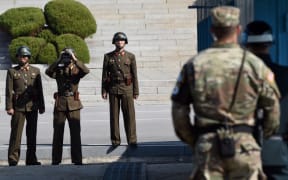 North Korean soldiers looking at the South side in a file photograph of the DMZ.