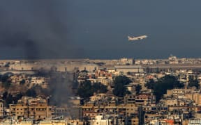 A Middle East Airlines commercial aircraft taking off from Beirut's international airport, amid smoke billowing above the Lebanese capital's southern suburbs, after Israeli strikes, on 28 September, 2024.