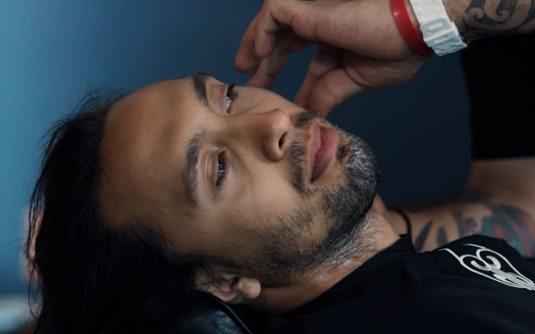 Kīngi reclined for a razor shave