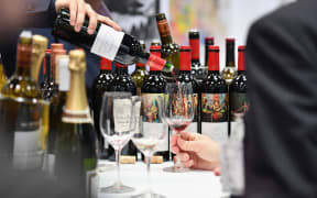 An exhibitor pours red wine during the Vinexpo at Javits Center on March 2, 2020 in New York City. The wine business dodged a bullet last month when the Trump administration held off on draconian European wine tariffs, but at a New York trade fair, the industry was not exactly celebrating. The spreading coronavirus joined the fog of US commerce policy, the murkiness of the British market post-Brexit and a glut of California wine among the leading buzz-kills at the Vinexpo. (Photo by Angela Weiss / AFP)