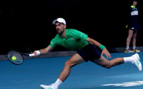 Serbia's Novak Djokovic hits a return to Italy's Lorenzo Musetti during their men's singles quarter-final match on day eleven of the Australian Open tennis tournament in Melbourne on January 28, 2026. (Photo by IZHAR KHAN / AFP) / -- IMAGE RESTRICTED TO EDITORIAL USE - STRICTLY NO COMMERCIAL USE --