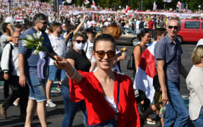 6309631 16.08.2020 Belarus opposition supporters carry flowers, balloons and historical white-red-white flags as they take part in "March of Freedom", in Minsk, Belarus.
