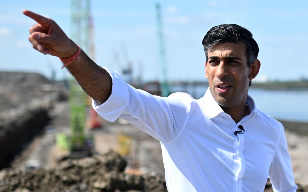 Conservative MP and Britain's former Chancellor of the Exchequer, Rishi Sunak gestures as he talks with Tees Valley Mayor Ben Houchen (unsen) during a visit to see the construction works at Teesside Freeport in Redcar, north East England on July 16, 2022, as part of his bid to become the next leader of the Conservative party. - Britain's Prime Minister, and leader of the ruling Conservative party Boris Johnson last week announced his resignation as Tory leader after a cabinet insurrection, following months of controversies. (Photo by Oli SCARFF / AFP)