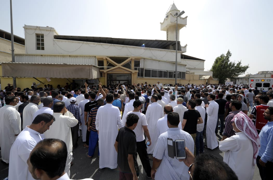 Man gather outside the mosque targeted with the deadly blast.