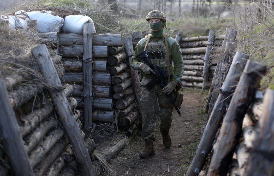 A Ukrainian serviceman patrols along a trench in Schastya, Lugansk region, near the frontline with Russia-backed separatists yesterday.