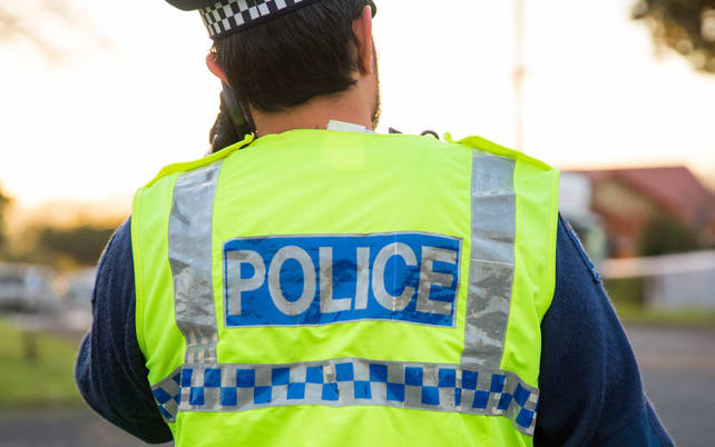A police officer outside a cordon in South Auckland.