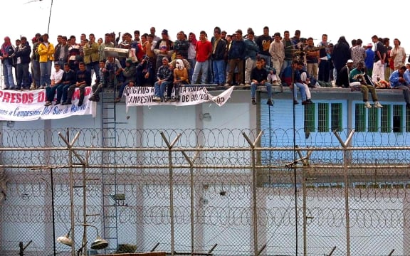 Inmates of the Modelo penitentiary in Bogota take control of a cellblock 16 February 2001, to show support for residents of the Bolivar province in southern Colombia.