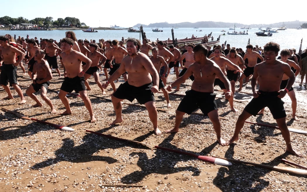 Kaihoe (paddlers) perform a mass haka on the beach. Photo: RNZ / Peter de Graaf
