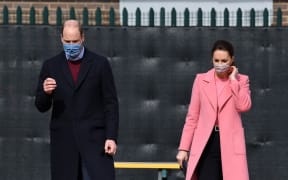 Britain's Prince William, Duke of Cambridge  and Britain's Catherine, Duchess of Cambridge gesture during a visit to School21 following its re-opening after the easing of coronavirus lockdown restrictions in east London on March 11, 2021.