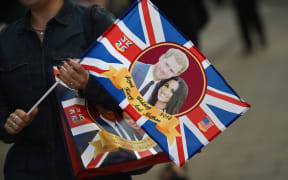 A visitor carries a bag featuring Britain's Prince Harry and US actress Meghan Markle as the country prepares for the Royal Wedding.