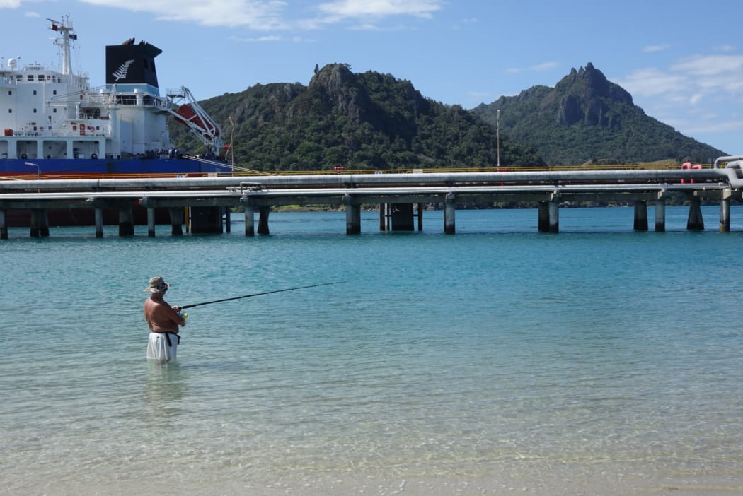 A man fishes in the waters at Marsden Point.