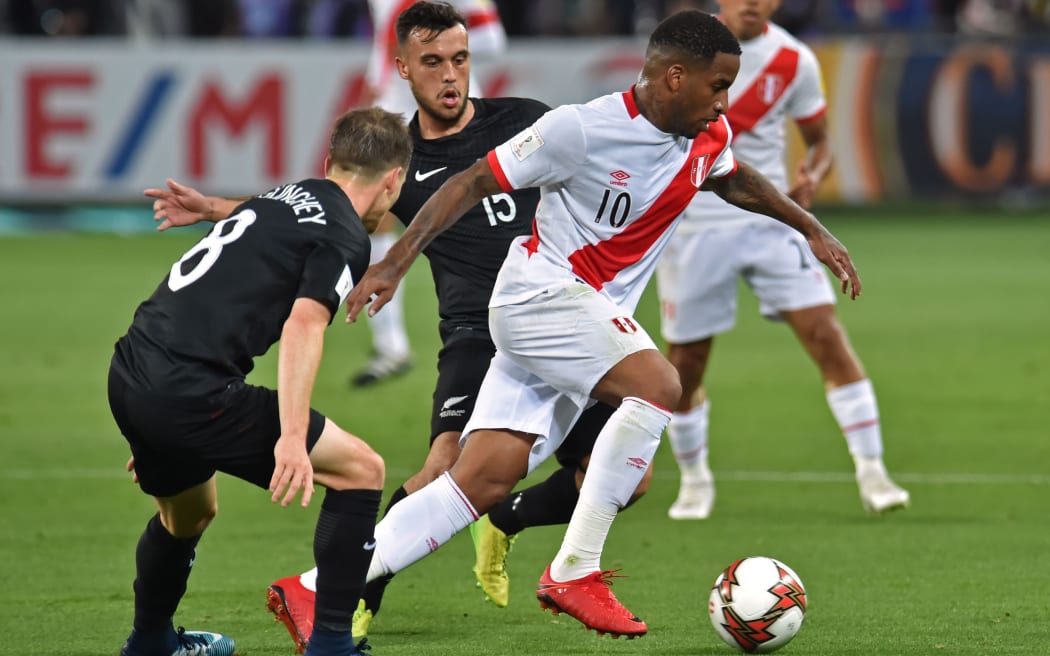 Peru's Jefferson Farfan takes on New Zealand's Michael McGlinchey (L) and Clayton Lewis.