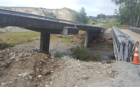 A damaged bridge and temporary replacement bridge on the road between Waiau and Mt Lyford.
