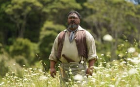 A Māori warrior standing in the field