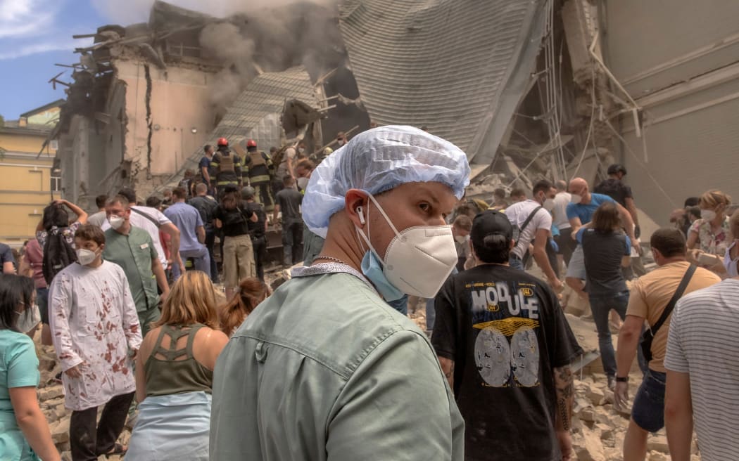 Volunteers, including medics, help emergency and rescue personnel to clear the rubble of a destroyed building at Ohmatdyt Children's Hospital following a Russian missile attack in the Ukrainian capital of Kyiv on July 8, 2024, amid the Russian invasion in Ukraine. (Photo by Roman PILIPEY / AFP)