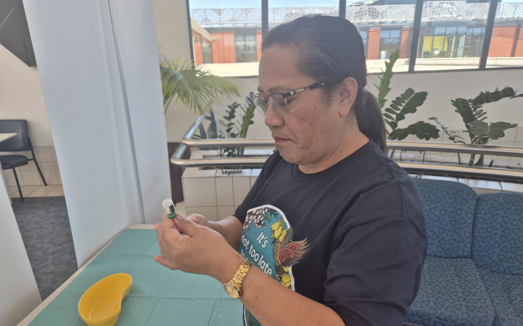 Vacinator Sita Moala preparing a measles vaccine dose