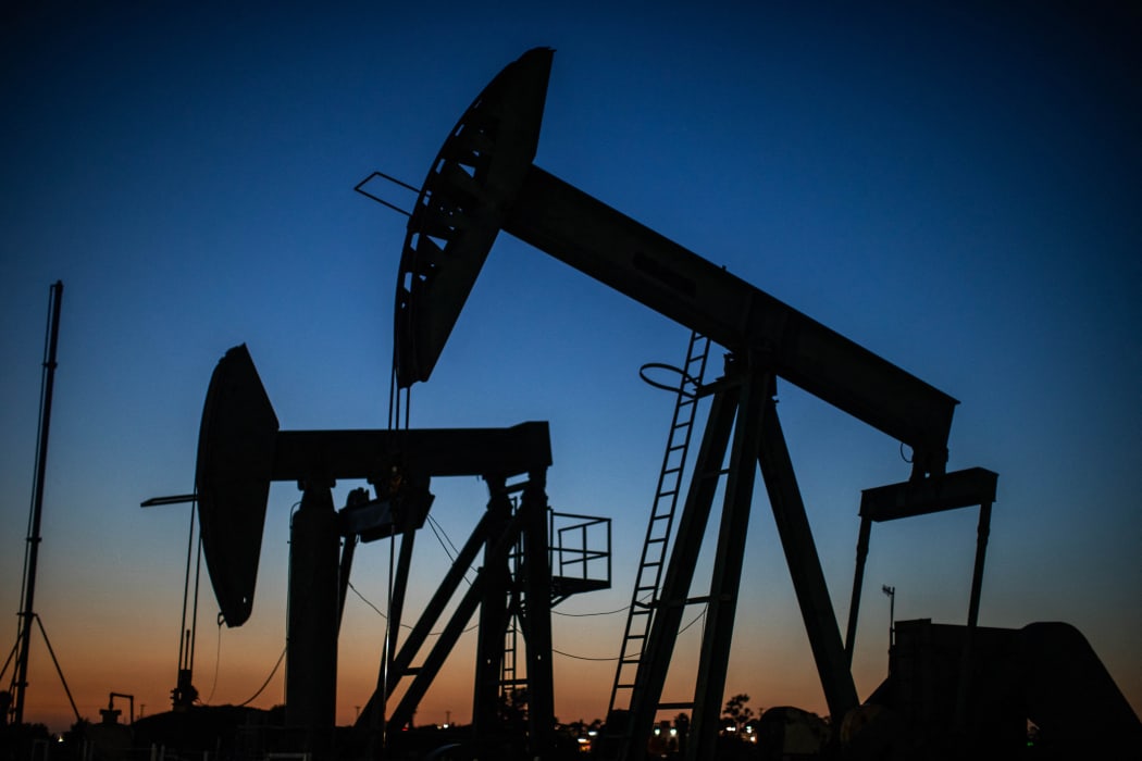 Oil pumpjacks operate at dusk Willow Springs Park in Long Beach, California on April 21, 2020.